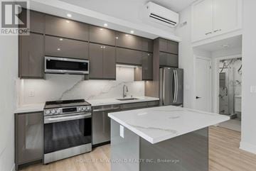 Toronto (Greenwood-Coxwell) apartment for rent - A modern kitchen with a stainless steel oven and a white countertop.