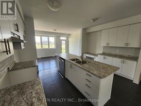 Brantford apartment for rent - A kitchen with granite countertops and white cabinets.