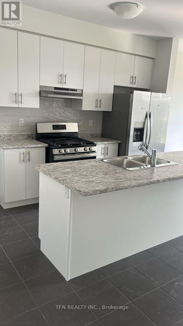 Brantford apartment for rent - A kitchen with white cabinets and a granite countertop.