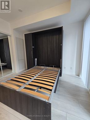 Toronto (Waterfront Communities) condo for rent - A bed with wooden slats is in a room with white walls.