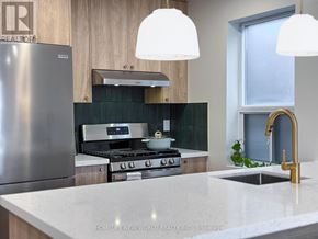 Toronto (South Riverdale) apartment for rent - A modern kitchen with a stainless steel refrigerator and a marble countertop.