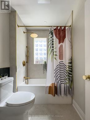 Toronto (South Riverdale) apartment for rent - A white toilet sits next to a bathtub in a bathroom.