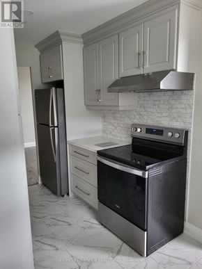 Markham (Thornhill) condo for rent - A kitchen with a black refrigerator and stove.