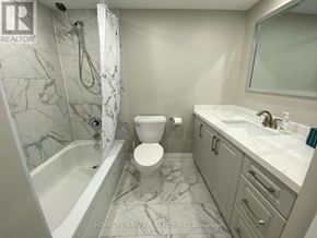 Markham (Thornhill) condo for rent - A white toilet is in a bathroom with a marble floor.
