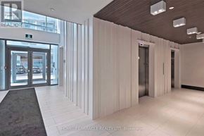 Toronto (York University Heights) condo for rent - A hallway with a carpeted area in front of a glass door.
