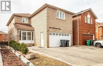 Mississauga (Hurontario) apartment for rent - A brick house with a white garage door is for sale.
