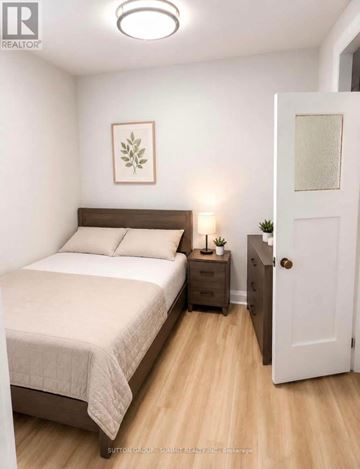 Toronto (Humewood-Cedarvale) condo for rent - A bedroom with a bed, nightstand, and a door.