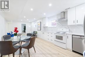 Mississauga (Rathwood) apartment for rent - A modern kitchen with white cabinets and a glass table.