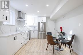 Mississauga (Rathwood) apartment for rent - A modern kitchen with a dining table set up.