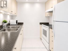 Toronto (Eglinton East) condo for rent - A modern kitchen with a white refrigerator, sink, and oven.