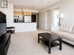 Toronto (Eglinton East) condo for rent - A living room with a white couch and a coffee table.