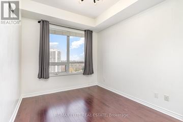 Toronto (Banbury-Don Mills) condo for rent - A living room with a grey couch and a large mirror.