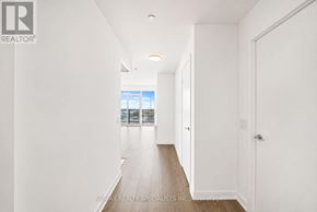 Toronto (South Parkdale) condo for rent - A long white hallway with a door on the right.