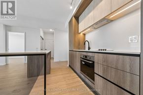 Mississauga (Central Erin Mills) condo for rent - A modern kitchen with wooden cabinets and a stainless steel oven.