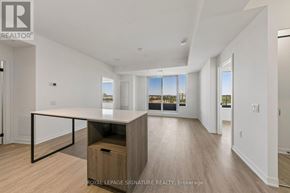 Mississauga (Central Erin Mills) condo for rent - A spacious room with a desk and a window overlooking a cityscape.