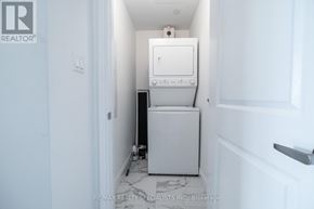 Hamilton (Stoney Creek) condo for rent - A white dryer is in a small, white-walled room.