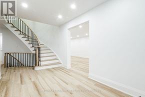 Mississauga (Sheridan) apartment for rent - A white interior space with a wooden staircase and light wood flooring.