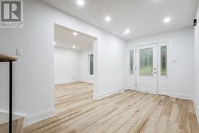 Mississauga (Sheridan) apartment for rent - A room with white walls and wooden flooring, with a door on the right side.
