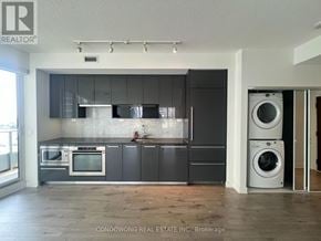 Toronto (Bayview Village) condo for rent - A modern kitchen with dark grey cabinets and a wooden floor.