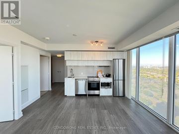 Toronto (Moss Park) condo for rent - A modern kitchen with white appliances and a large window overlooking the city.