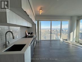 Toronto (Moss Park) condo for rent - A modern kitchen with a large window overlooking a cityscape.