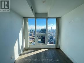 Toronto (Moss Park) condo for rent - A room with a large window overlooking a cityscape.