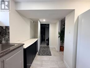 Oshawa (Centennial) apartment for rent - A hallway with a rug on the floor leading to a door.