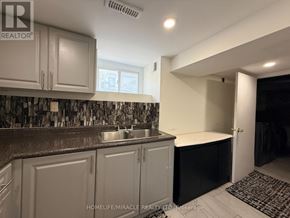 Oshawa (Centennial) apartment for rent - A kitchen with white cabinets and a black countertop.