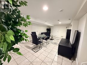 Oshawa (Centennial) apartment for rent - A living room with a black sofa, a black chair, and a black cabinet.