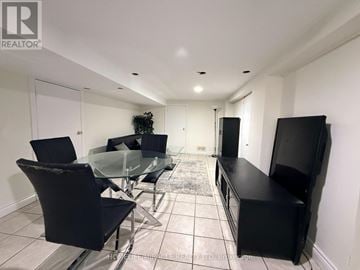 Oshawa (Centennial) apartment for rent - A modern living room with a glass table and black chairs.