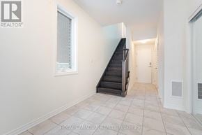Pickering townhouse for rent - A spacious hallway with a staircase leading to the second floor.