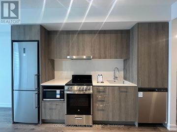 Vaughan (Concord) condo for rent - A modern kitchen with wooden cabinets and stainless steel appliances.