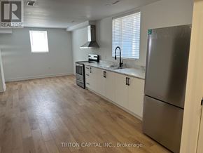 Barrie apartment for rent - A kitchen with a refrigerator, sink, and stove.