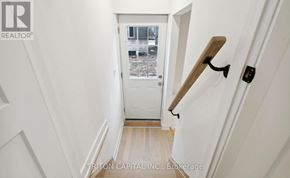 Barrie apartment for rent - A hallway with a white door and a wooden staircase.