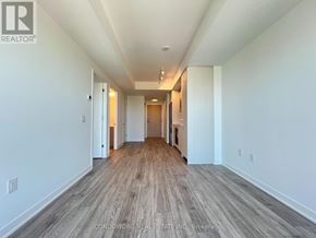 Toronto (Regent Park) condo for rent - A long hallway with wood floors and white walls.