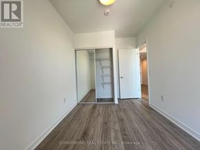 Toronto (Regent Park) condo for rent - A room with a white wall and a wooden floor.