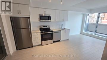 Toronto (Humber Heights) condo for rent - A modern kitchen with stainless steel appliances and white cabinets.