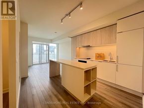 Toronto (Church-Yonge Corridor) condo for rent - A kitchen area with wooden floors and white cabinets.