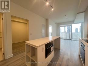 Toronto (Church-Yonge Corridor) condo for rent - A kitchen with a white island and wooden floors.