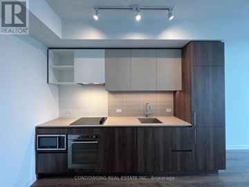 Vaughan (Vaughan Corporate Centre) condo for rent - A modern kitchen with dark wood cabinets and stainless steel appliances.