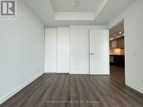 Vaughan (Vaughan Corporate Centre) condo for rent - A room with white walls and wooden flooring with a white door.