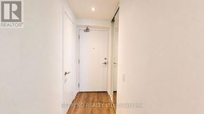 Vaughan (Vaughan Corporate Centre) condo for rent - A hallway with a white door and a brokerage sign on the wall.