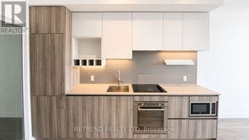 Vaughan (Vaughan Corporate Centre) condo for rent - A modern kitchen with wooden cabinets and a stainless steel sink.