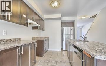 Cambridge townhouse for rent - A kitchen with brown cabinets and granite countertops.