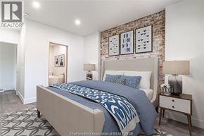 Chatham apartment for rent - A bedroom with a large bed and a brick wall above it.