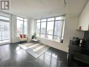 Toronto (Church-Yonge Corridor) condo for rent - A living room with a large window and a view of the city.