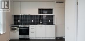Toronto (Church-Yonge Corridor) condo for rent - A kitchen with white cabinets and black countertops.