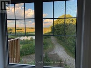 Markham (Victoria Square) townhouse for rent - A window with a view of a dirt road and greenery.