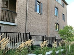 Markham (Victoria Square) townhouse for rent - A brick building with a balcony and a black fence.