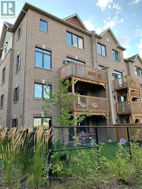 Markham (Victoria Square) townhouse for rent - A large apartment building with balconies and a fence in front.